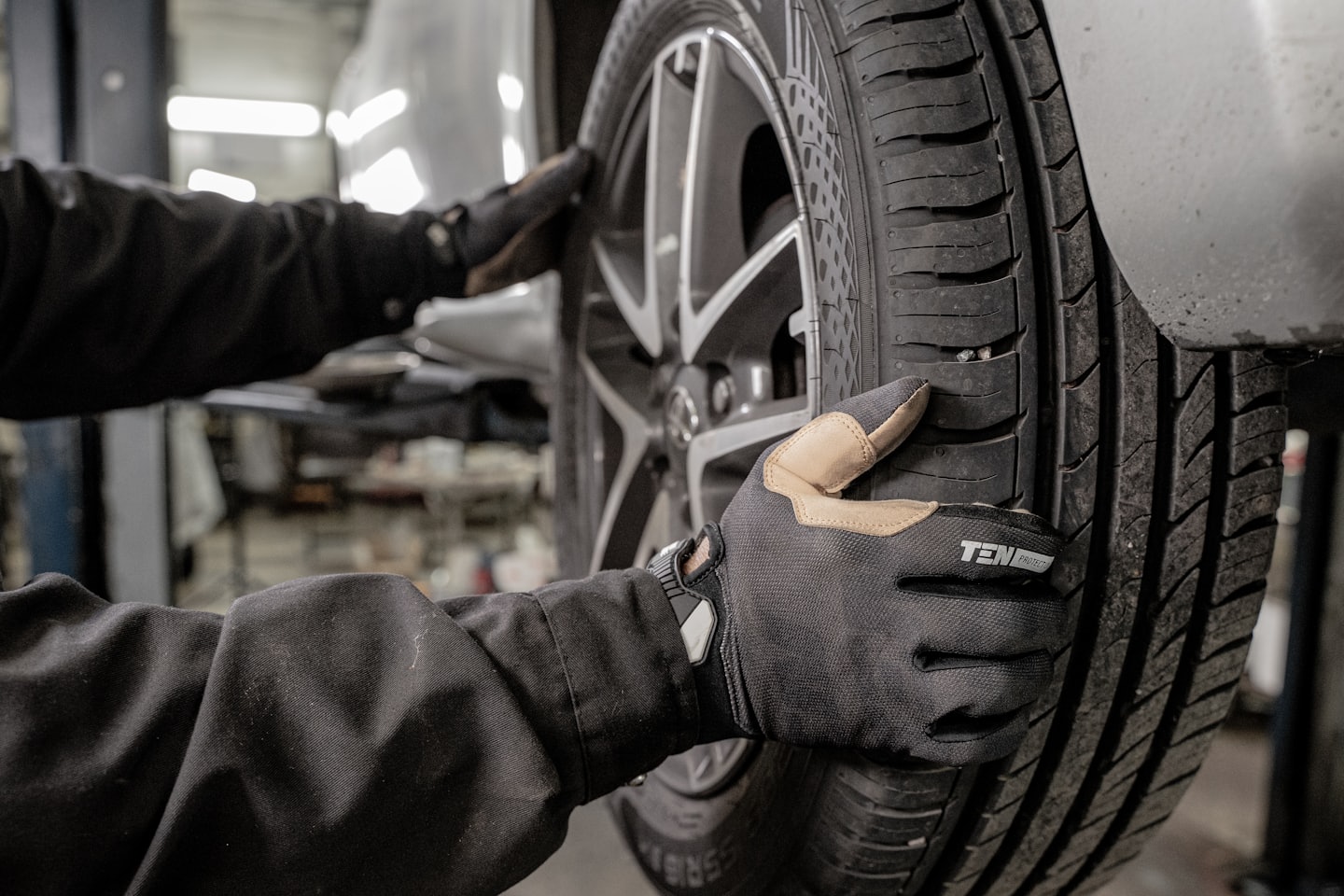 Mechanik kontroluje pneumatiku auta na zliatinovom disku.